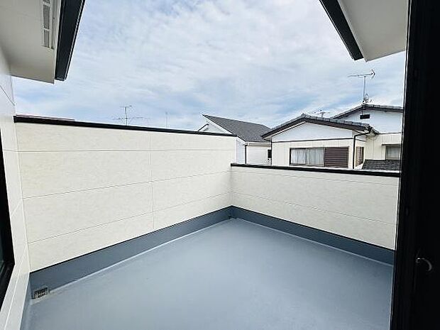 広々としたバルコニーはプライバシーを確保しやすい設計です。視界を遮る高めの壁が特徴的です。防水仕様の床でメンテナンスも簡単です。空の広がりを感じられるスペースになっています。