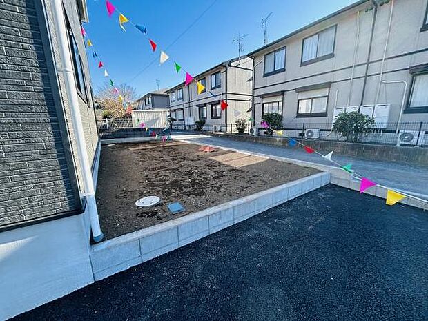 シンプルな造りの庭が広がっており使い方を自由に検討できます。家のすぐそばに位置しているのでアクセスも便利です。手入れのしやすい形状が魅力です。カラフルな旗がアクセントになっています。