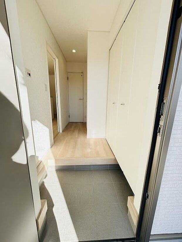 明るい玄関スペースが印象的です。清潔感のある白を基調とした内装が広がりを感じさせます。段差が緩やかで出入りがしやすい設計となっています。収納スペースも豊富で整理整頓がしやすいです。