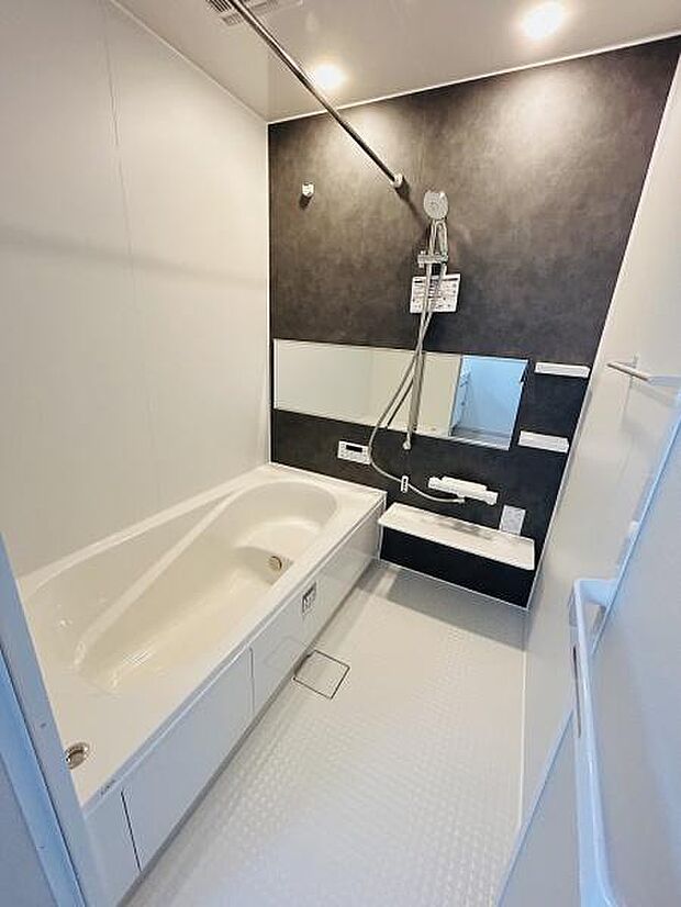 シンプルなデザインで清潔感がありゆったりとした広さのバスルームです。壁面のダークカラーが空間のアクセントになっています。浴槽は直線的なフォルムで使いやすい形状です。