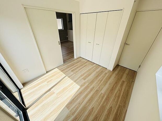 明るい色調のフローリングが特徴の洋室です。大きなクローゼットがあり収納も充実しています。引き戸を採用し空間を有効に使える設計です。窓からの採光で室内が明るく保たれます。