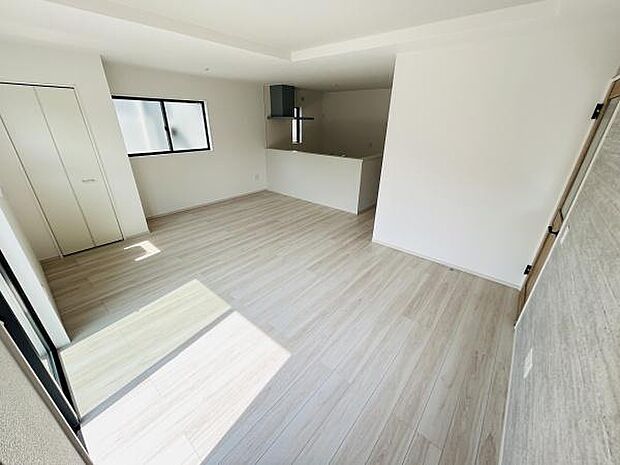 明るい日差しが差し込むリビングはシンプルな内装で空間を広く感じられます。床や壁のトーンが統一されていて清潔感があります。収納スペースも備わっており使い勝手の良い設計です。