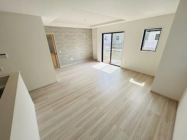 明るい光が差し込むリビングです。床材はナチュラルな色味で空間全体を広く感じさせます。窓が多く開放的な印象です。壁面のアクセントがシンプルな中にもデザイン性を感じさせます。