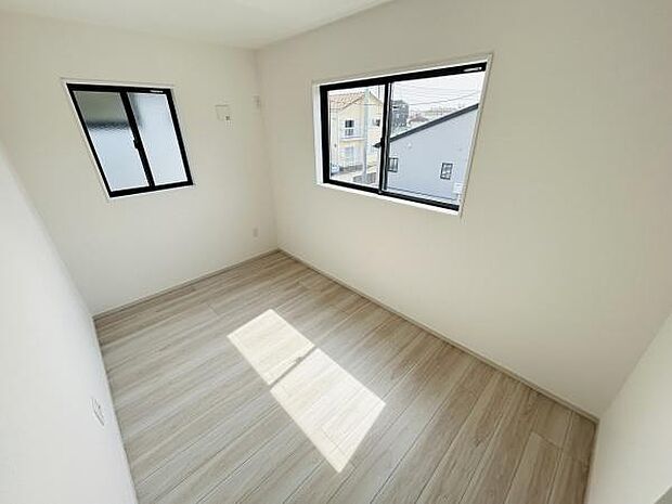 窓が二面にあり日差しが差し込む明るい洋室です。壁や床の色合いが落ち着いた印象を与えます。シンプルな内装で家具の配置もしやすいお部屋です。住まいの快適さを感じられる空間です。