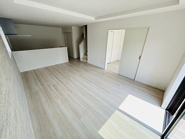 リビング全体に明るさが広がる開放的な空間です。床や壁も優しい色合いで統一されており清潔感があります。キッチンとのつながりもスムーズで移動が便利です。収納や動線設計も考えられた使いやすいレイアウトです。