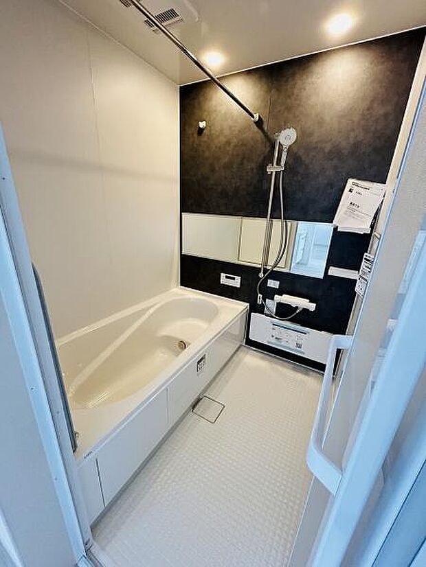 広々とした浴槽を備え毎日の入浴が快適に過ごせます。ダークトーンのアクセントパネルが落ち着いた雰囲気を演出します。シャワーや鏡など機能的な設備も整っておりお手入れしやすいユニットバスです。