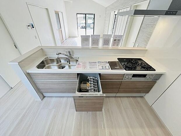 キッチンはカウンター付きで開放感があり料理の際も快適に作業できます。食器洗い乾燥機や三口コンロがあり日々のお手入れも簡単です。シンクと作業スペースが広く効率よく調理ができます。