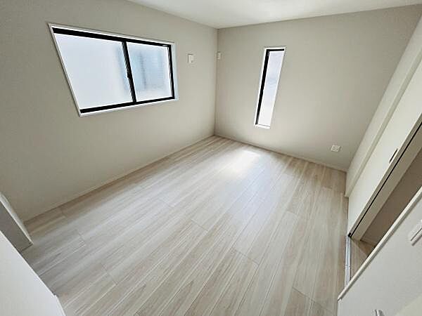 窓から光が差し込む明るい寝室です。ナチュラルなフローリングが室内全体に落ち着いた雰囲気を演出します。壁面がシンプルなので家具の配置もしやすい寝室となっています。