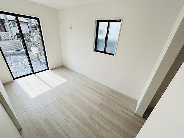 明るい日差しが差し込む洋室です。シンプルな内装ですっきりとした空間になっています。大きな窓からの開放感が魅力です。床材の色合いも落ち着いており幅広いインテリアに合います。