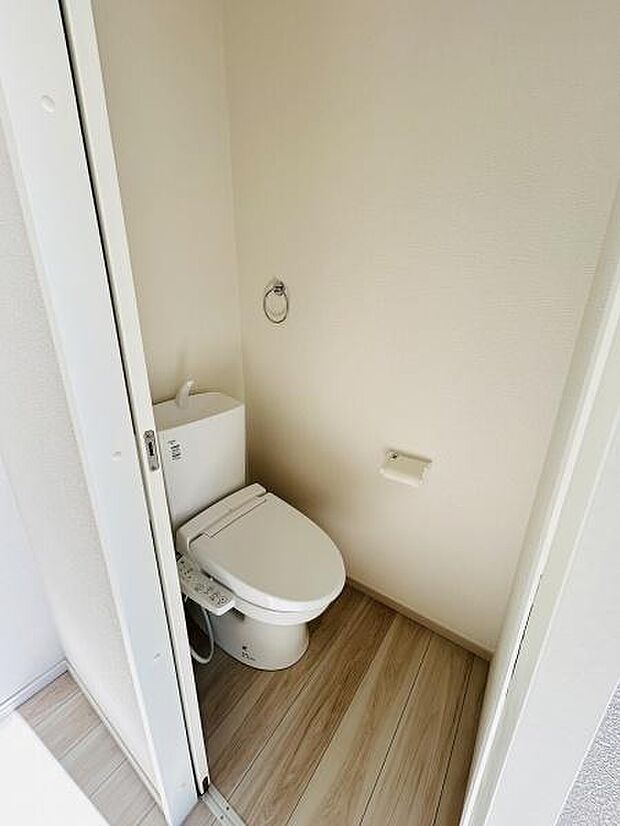清潔感のあるトイレ空間です。シンプルな内装が特徴です。床材のデザインがアクセントになっています。手洗い機能も備えられています。壁は明るい色合いでまとめられています。
