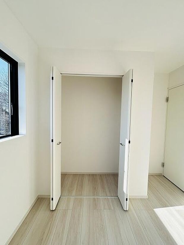 シンプルなデザインの収納スペースは使い勝手の良さが魅力です。扉付きで見た目もすっきりとしています。床や壁の色合いと調和した内装で明るい雰囲気が感じられます。