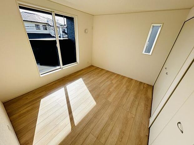 大きな窓から光が差し込む明るい寝室です。木目調のフローリングが温かみを演出しています。収納スペースも備わっています。壁面もシンプルで家具配置がしやすいです。