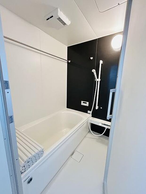 シンプルなデザインで清潔感のあるバスルームです。浴槽はゆったりとした広さがありリラックスできる空間です。手すりやシャワーヘッドも使いやすく配置されています。