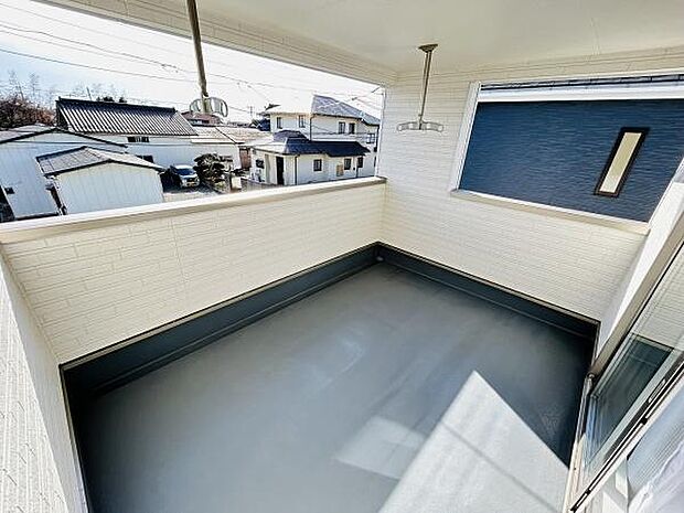 広々としたバルコニーで開放感のある空間が印象的です。日当たりも良好で洗濯物の乾きやすさが期待できます。高めの壁でプライバシーにも配慮されています。屋根付きなので天候に左右されにくい設計です。