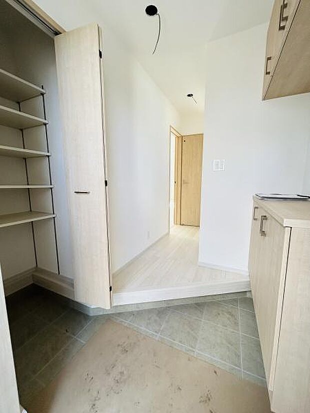 収納力を感じさせる玄関スペースです。明るい色合いの建具が空間を軽やかに演出しています。玄関収納が充実しており整理整頓がしやすい設計です。広めの土間部分が使いやすさをサポートします。