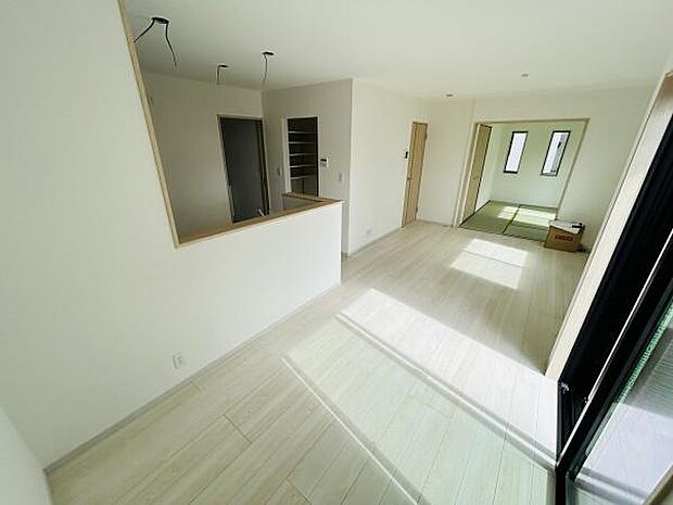 リビングは明るい日差しが広がる空間です。ホワイトを基調とした床と壁がシンプルで洗練された印象を与えます。隣接する和室とのつながりがあり開放感も感じられます。