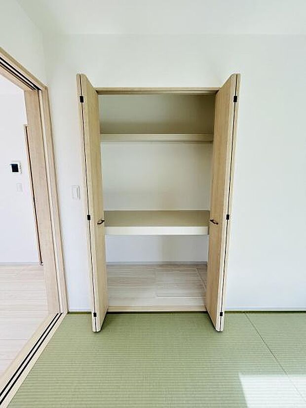 扉付きの収納スペースで室内がすっきりとした印象になります。棚板が複数設置されているため物の整理に便利です。明るい色味の木目調が空間に馴染みやすいデザインです。畳のお部屋にも調和する収納です。