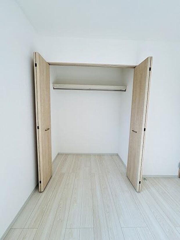 木目調の扉がシンプルな印象を与える収納スペースです。開口部が広く出し入れがしやすい設計です。棚とハンガーパイプが備わっており衣類や小物も整頓しやすい仕様です。