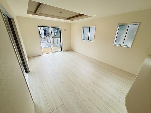 大きな窓から自然光が差し込む明るく爽やかなリビングです。シンプルな内装が空間を引き立てています。白を基調としたフローリングで開放感があります。ゆとりのある広さが魅力的です。