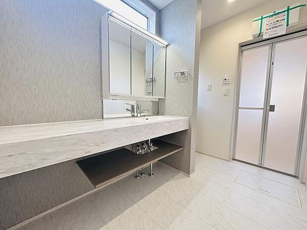 広々とした洗面台は朝の準備もスムーズに行えます。清潔感のある明るい空間が印象的です。鏡裏収納も備わっておりすっきりとした見た目を実現しています。足元の収納スペースも活用でき機能性が高い洗面所です。