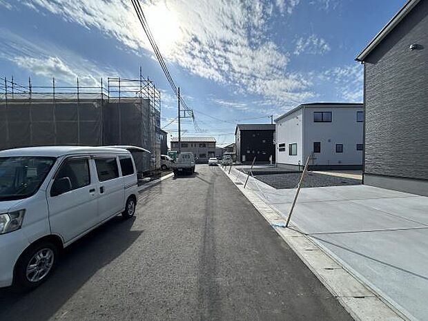前面道路は整備されており車の出入りもスムーズに行えます。周辺は新しい建物が多く街並みに統一感があります。道路幅が確保されており大きめの車も安心して駐車できます。明るい空が広がり開放感ある現地環境です。