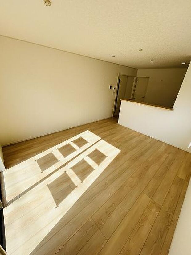 明るいリビングが特徴的です。ナチュラルなフローリングが空間を広々と感じさせます。シンプルな内装で好みのアレンジがしやすい点もポイントです。天井のダウンライトもすっきりとした印象です。