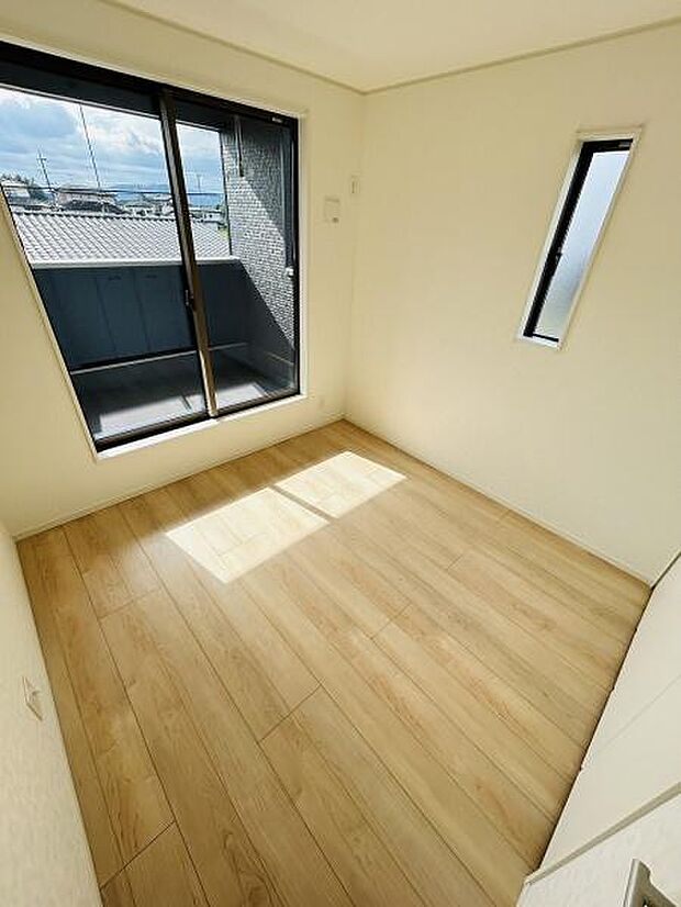 明るい日差しが差し込む子供部屋です。バルコニーに面した大きな窓が開放感をもたらします。シンプルなフローリングでお手入れも簡単です。スリムな縦窓が空間にアクセントを加えています。
