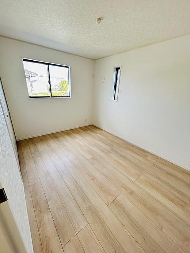 明るい日差しが差し込む洋室です。シンプルな内装はさまざまなインテリアと調和しやすいです。木目調の床が落ち着いた印象を与えます。二面採光で開放感があります。