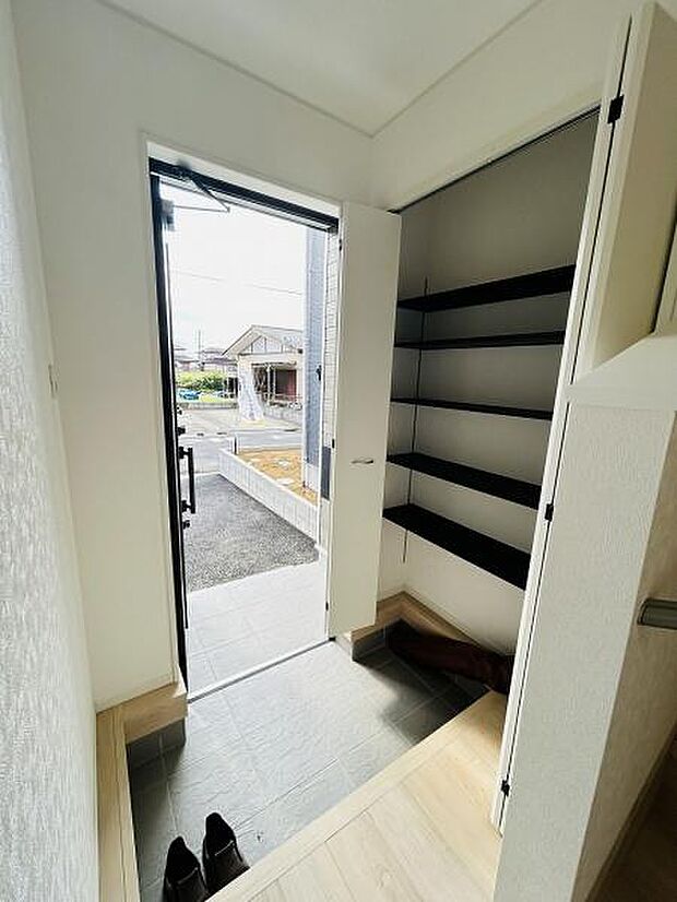 明るい玄関スペースが魅力です。収納棚が設置されており整理整頓がしやすい仕様です。タイル床でお手入れも簡単です。玄関ドアから外への動線もスムーズです。空間に開放感があります。