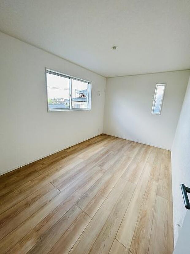 明るい自然光が差し込む寝室です。ナチュラルなフローリングが温かみを感じさせる空間となっています。窓が二箇所あるため換気もしやすい設計です。すっきりとしたレイアウトで多様な使い方ができます。