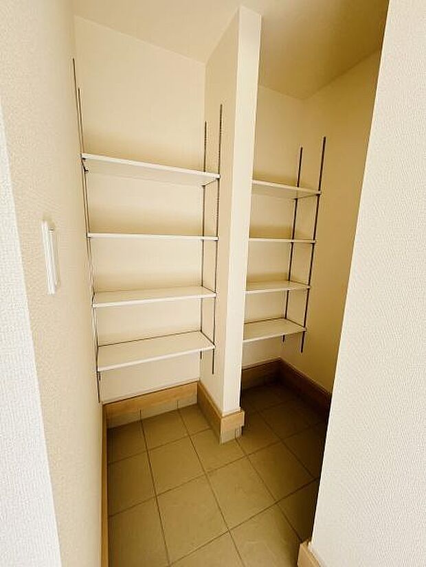 玄関には可動式の棚が複数設置されており整理整頓がしやすい設計です。壁を活かしたレイアウトで空間を広く感じられます。土間スペースも確保されており使い勝手の良い造りになっています。