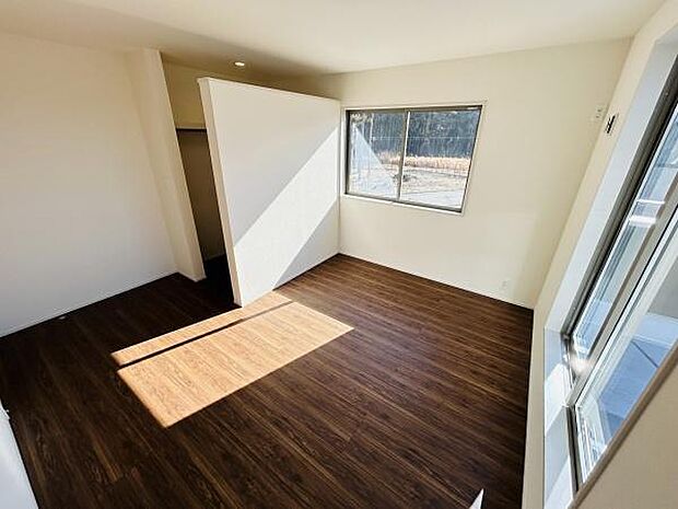 広々とした空間に大きな窓からたっぷりと日差しが差し込みます。床材の質感が落ち着いた印象を与えます。収納スペースも確保されているので使い勝手の良い寝室です。