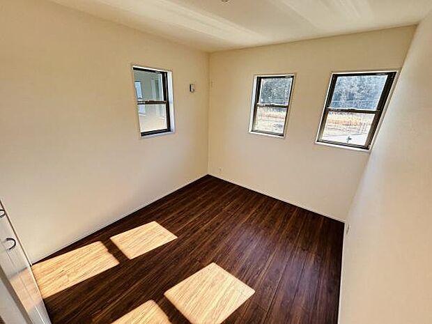 三つの窓からたっぷりと光が差し込む明るい空間です。壁と床のコントラストが印象的な内装となっています。収納スペースも確保されています。過ごしやすさを重視したお部屋です。清潔感のある子供部屋です。