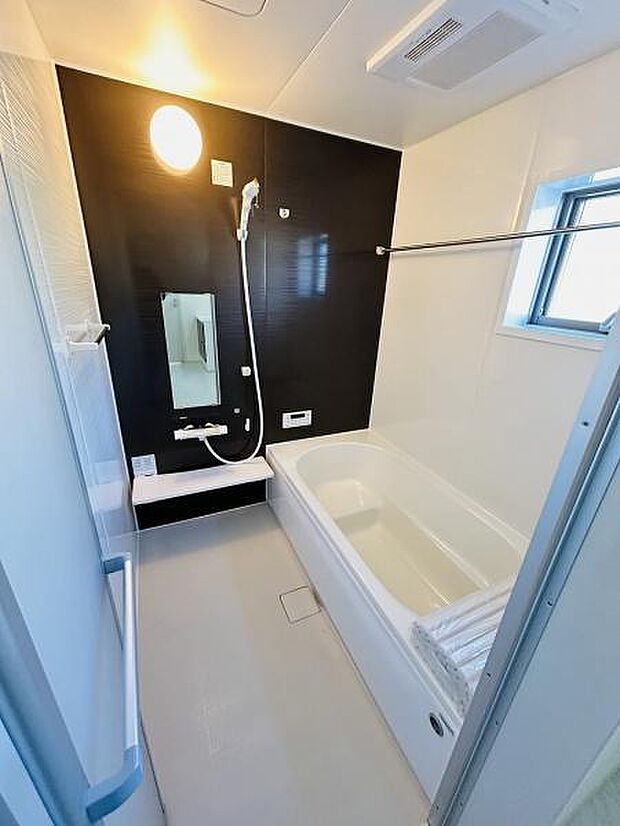 清潔感のある浴室で明るい照明が印象的です。浴槽とシャワースペースが広く快適にご利用いただけます。窓付きで換気もしやすい設計となっております。壁のアクセントカラーが空間にメリハリを与えています。