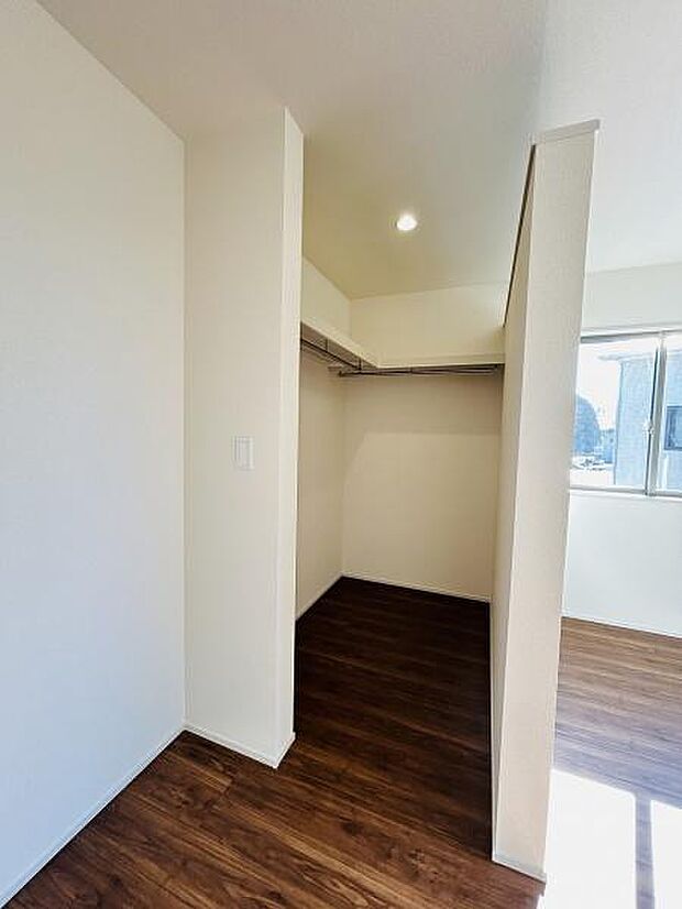 ウォークインタイプの収納スペースが用意されています。室内は明るさがあり出し入れもしやすい空間です。ハンガーパイプが設置されており衣類を掛けるのに便利です。