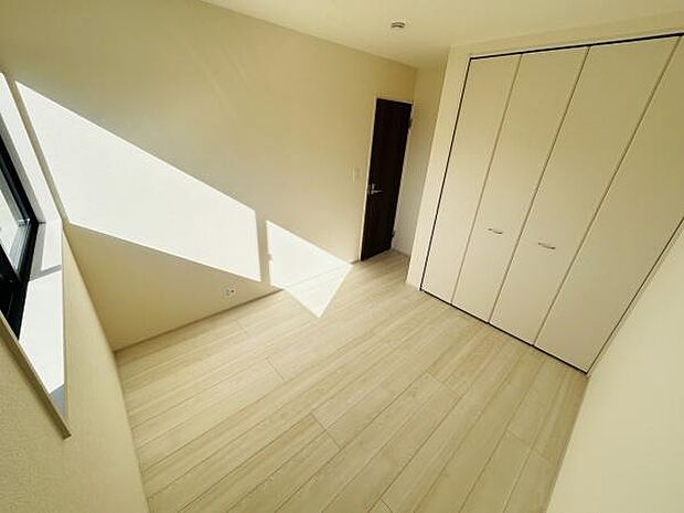 明るい光が差し込む洋室です。ナチュラルな色合いのフローリングが室内を柔らかく演出しています。大型クローゼットが備わっているため収納も便利です。すっきりとした空間が広がります。