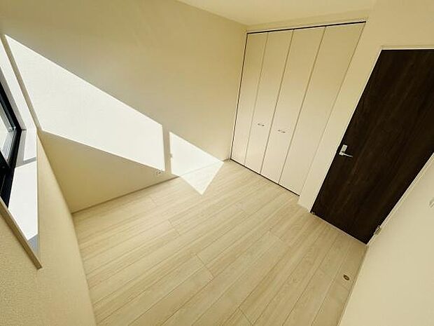 洋室には明るい光が差し込み開放感を感じられます。床や建具の色合いが統一されていて落ち着いた印象です。収納力のあるクローゼットも備わっています。扉の設計がシンプルで室内がすっきりと見えます。