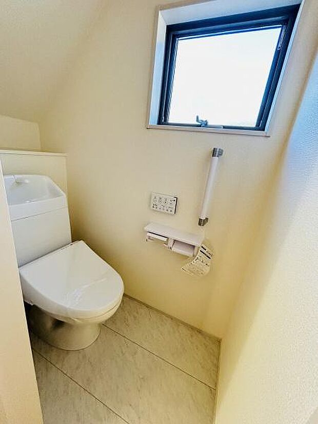 窓付きのトイレで自然光を取り入れることができます。シンプルで清潔感のある内装が特徴です。手すりが設置されているため安心感もあります。コンパクトな空間で使い勝手も良好です。