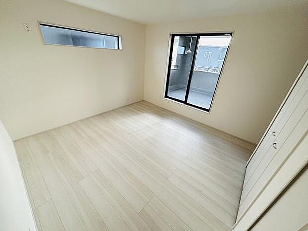 明るいフローリングが空間を広く見せるリビングです。大きな窓から光が差し込みます。シンプルな内装で使いやすいデザインです。収納スペースも備え付けられています。