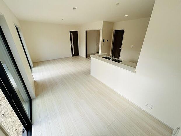 リビングはナチュラルなフローリングが明るい印象を与えます。大きな窓からたっぷりと光が差し込み開放感があります。キッチンとのつながりもスムーズで使い勝手のよいレイアウトです。