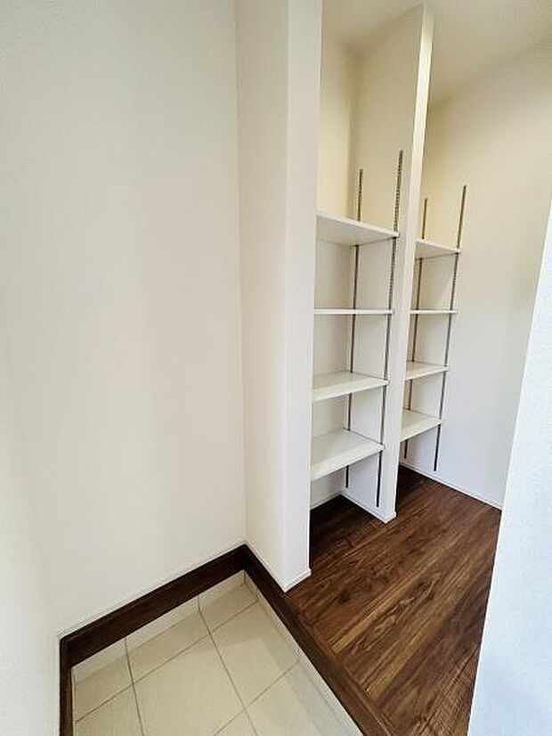 玄関には可動式の棚が設置されており整理整頓がしやすいつくりです。明るい色合いの内装で清潔感のある印象です。床はタイルとフローリングが分かれていてお手入れもしやすい仕様です。