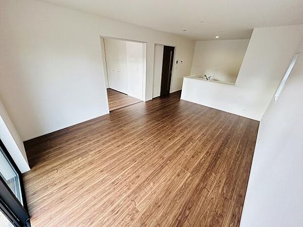 リビングはナチュラルな木目調のフローリングが特徴です。仕切りが少なく開放感があります。大きな窓から光が入り空間が明るくなっています。キッチンとの動線も便利です。