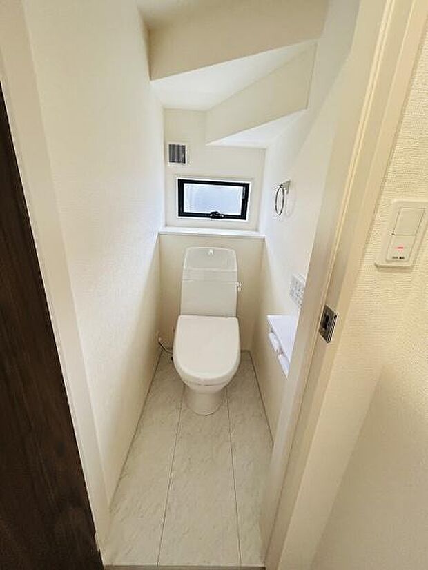 コンパクトな空間に窓があり明るさが感じられます。清潔感のある白を基調とした内装です。収納やペーパーホルダーも使いやすい位置に配置されています。換気設備も備わっています。