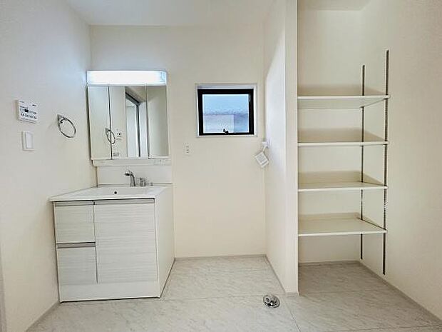 明るい洗面台エリアが広々と設計されています。収納棚が複数設けられており整理整頓に便利です。シンプルな内装でお手入れが楽に行えます。窓があるため換気も行いやすい仕様です。清潔感のある空間です。
