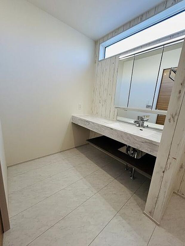 大きな鏡と明るい窓が設けられており開放感のある洗面台です。シンプルなデザインでお手入れがしやすい空間です。下部に収納スペースがあるため物の整理にも便利です。毎日の身支度に使いやすい仕様となっています。