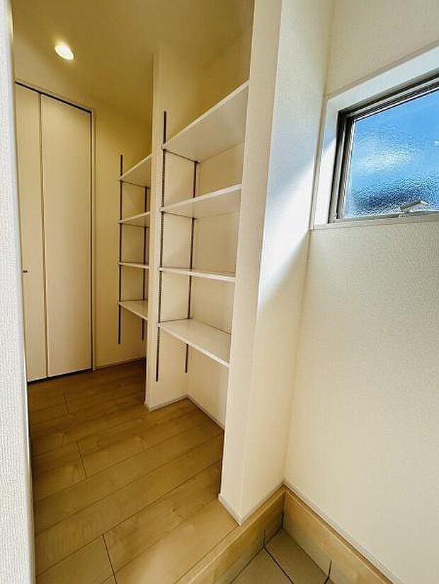 明るい玄関には使い勝手の良い棚が設置されています。収納スペースが豊富で空間をすっきりと保てます。小窓から自然光が差し込み玄関全体を爽やかに演出しています。シンプルなデザインで清潔感があります。