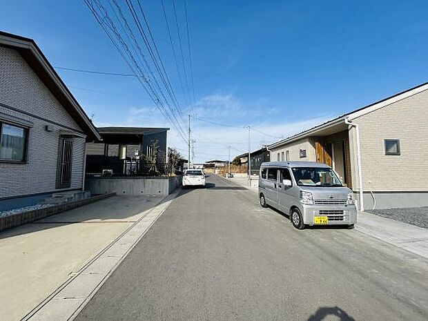 前面道路が広く車の出し入れがしやすい環境です。周辺は落ち着いた雰囲気が広がっています。両側に住宅が整然と並び整った街並みが印象的です。青空の下で明るい印象を受けます。