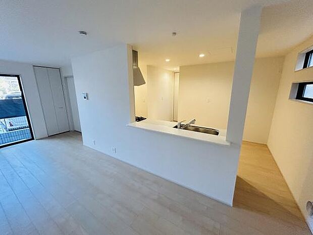 リビングは明るいフローリングが特徴で清潔感のある空間です。対面式のキッチンが設置されており使い勝手の良い間取りです。大きな窓からの採光が印象的で開放感があります。収納スペースも確保されています。