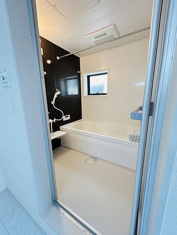 シンプルな配色で清潔感のあるバスルームです。窓付きで自然な明るさが取り込めます。広めの浴槽が設置されています。バスルームが使いやすい設計になっています。快適な入浴をサポートします。