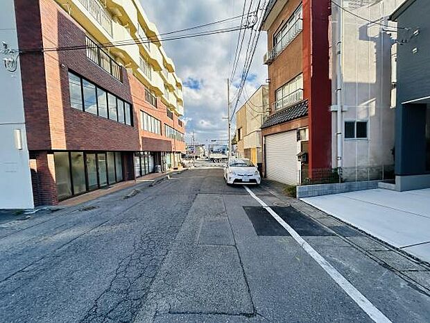 前面道路は幅員が確保されており車の通行や駐車がしやすい環境です。周辺には建物が整然と並び都市的な雰囲気が感じられます。歩道もしっかりと整備されていて安全面にも配慮されています。